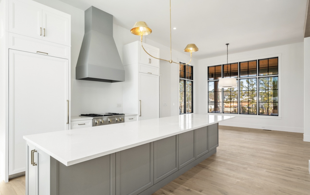 Modern kitchen island with quartz counters and brass fixtures